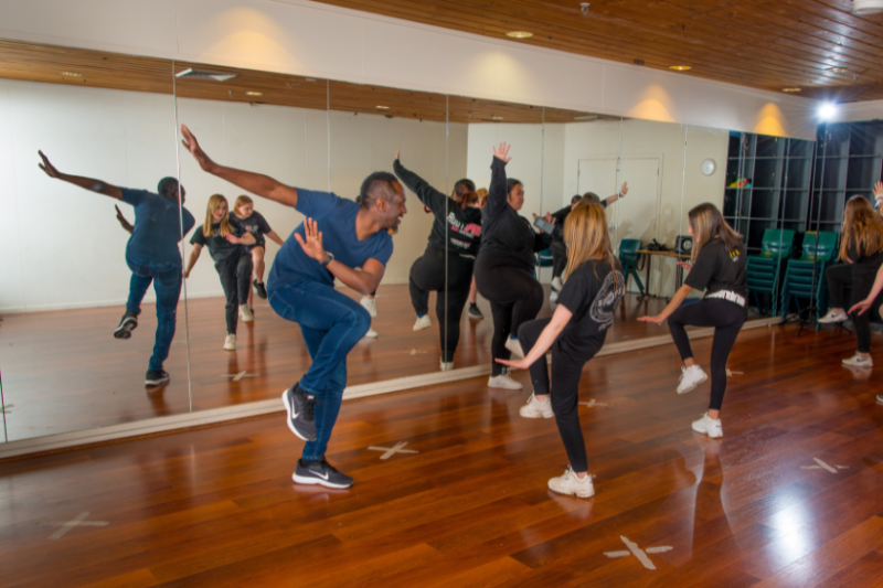Francis Owusu dancing with students.